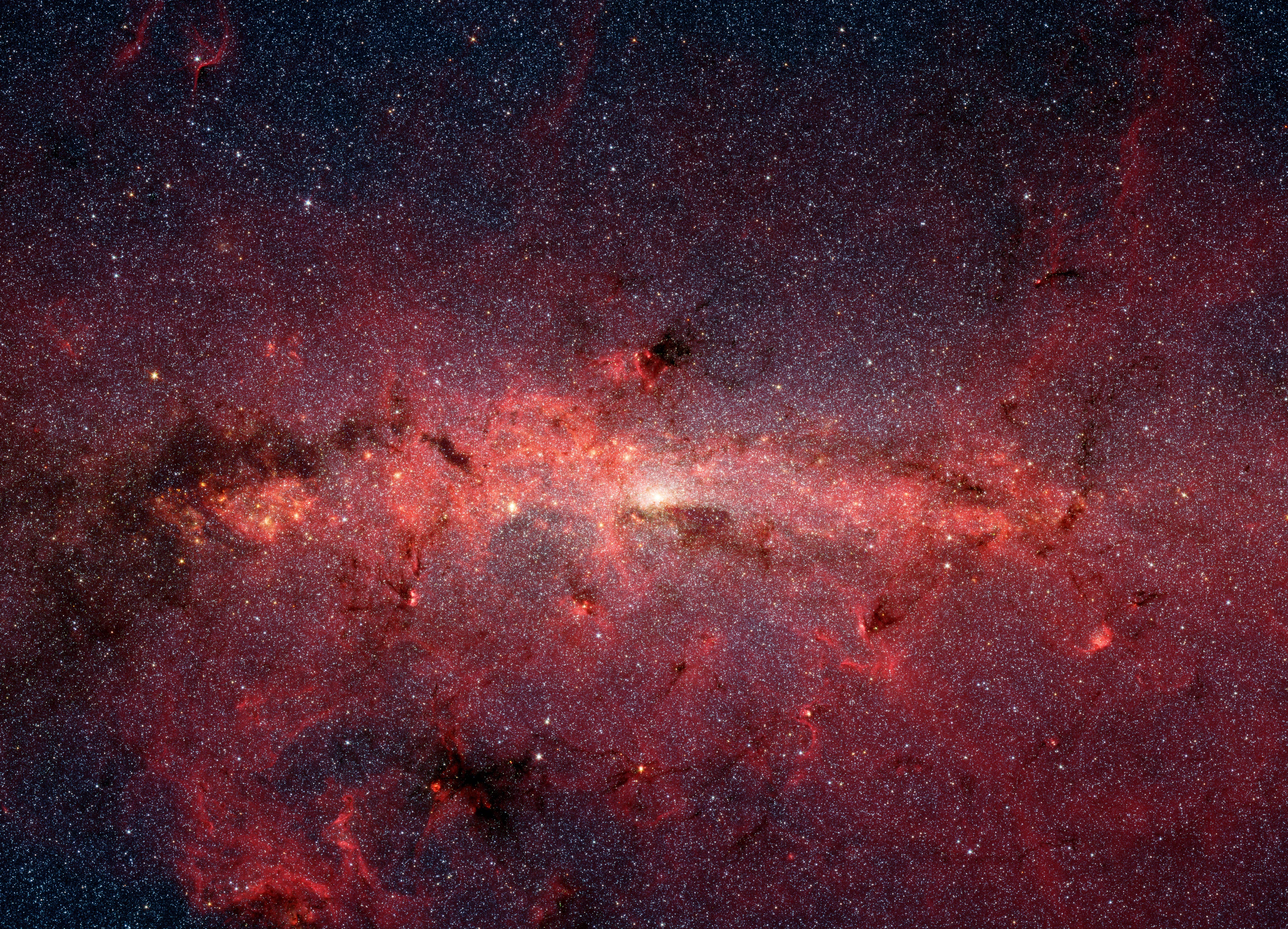 A large image (7002 x 5050 pixels, 7.726.879 bytes) of the billions of stars at the center of our our galaxy the Milky Way. Target Name: Milky Way, Mission: Spitzer Space Telescope, Instrument: IRAC, Produced By: California Institute of Technology, TIF version (106.1 MB): http://photojournal.jpl.nasa.gov/tiff/PIA03654.tif, Image Credit: NASA/JPL-Caltech. 

This dazzling infrared image from NASA's Spitzer Space Telescope shows hundreds of thousands of stars crowded into the swirling core of our spiral Milky Way galaxy. In visible-light pictures, this region cannot be seen at all because dust lying between Earth and the galactic center blocks our view.

In this false-color picture, old and cool stars are blue, while dust features lit up by blazing hot, massive stars are shown in a reddish hue. Both bright and dark filamentary clouds can be seen, many of which harbor stellar nurseries. The plane of the Milky Way's flat disk is apparent as the main, horizontal band of clouds. The brightest white spot in the middle is the very center of the galaxy, which also marks the site of a supermassive black hole.

The region pictured here is immense, with a horizontal span of 890 light-years and a vertical span of 640 light-years. Earth is located 26,000 light-years away, out in one of the Milky Way's spiral arms. Though most of the objects seen in this image are located at the galactic center, the features above and below the galactic plane tend to lie closer to Earth.

Scientists are intrigued by the giant lobes of dust extending away from the plane of the galaxy. They believe the lobes may have been formed by winds from massive stars.

This image is a mosaic of thousands of short exposures taken by Spitzer's infrared array camera, showing emissions from wavelengths of 3.6 microns (blue), 4.5 microns (green), 5.8 microns (orange), and 8.0 microns (red). The entire region was imaged in less than 16 hours.
